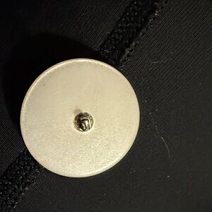 Elegant Black Garment with Carved Cream Buttons